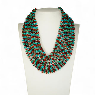 Turquoise and red beaded necklace on a white mannequin bust.