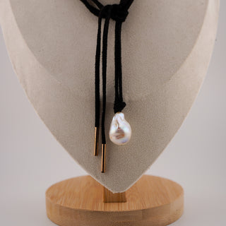 Elegant black cord necklace with large baroque pearl pendant, showcasing unique character and beauty. Perfect for any outfit.