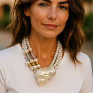 Stylish woman wearing the Ocean’s Majesty: Layered Shell & Faux Pearl Statement Necklace, radiating elegance.