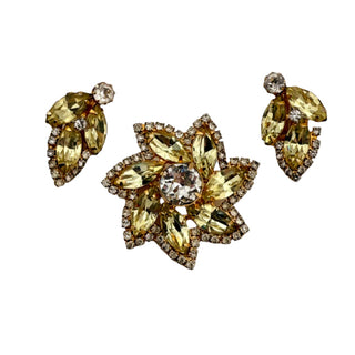 Gold and yellow gemstone jewelry set on a light gray background