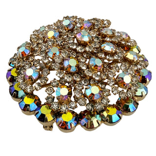 Decorative brooch with multicolored gemstones on a light gray background
