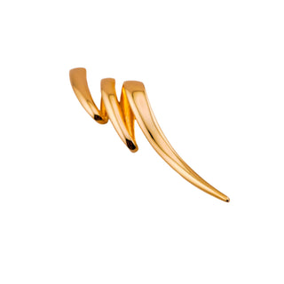 Gold earring on a light gray background