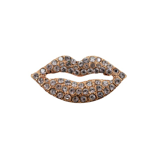 Jeweled lip-shaped brooch on a gray background