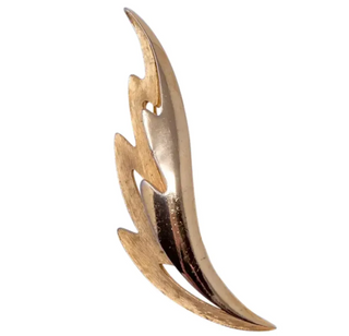 A gold-tone metal brooch in a stylized split leaf shape with a textured finish.