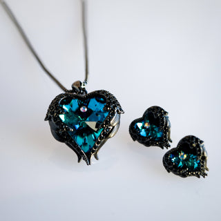 Heart-shaped jewelry set with teal gemstones on a white background