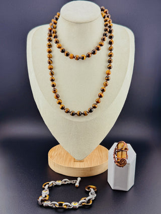 Jewelry set including a necklace, bracelet, and ring on a dark background