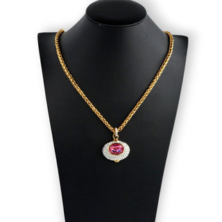 A Nolan Miller Large Pink Crystal Goddess Necklace Reversible Pendant displayed on a black mannequin. The necklace has a gold-tone chain and a dual-sided pendant with a faceted pink oval crystal on one side, surrounded by clear rhinestones.