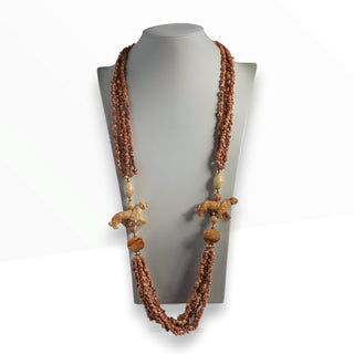 Necklace with brown beads and decorative elements on a mannequin bust against a white background