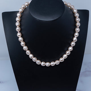 A vintage freshwater simulated pearl necklace displayed on a black mannequin stand.