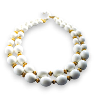 A vintage Trifari necklace featuring gold-colored beads and white lucite, with an adjustable fit.