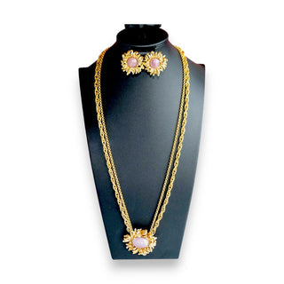 A vintage Oscar de la Renta gold-tone flower necklace and matching clip-on earrings set on a black mannequin.