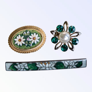 Three decorative brooches on a white background
