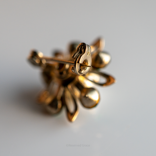 Gold earring on a light gray background
