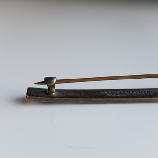 Vintage metal brooch on a plain background