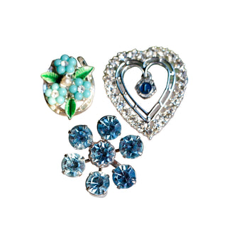 Three decorative brooches on a white background