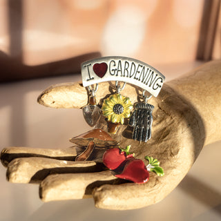 Decorative brooch with 'I ❤️ Gardening' text on a wooden surface