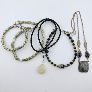 Reserved Grace artisanal jewelry set featuring patterned ceramic beads, black cord, hematite, and silver necklaces.