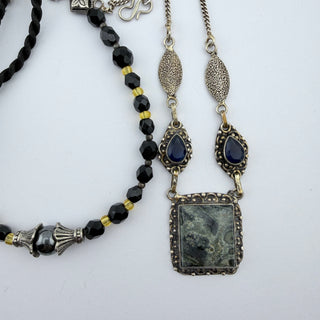 Reserved Grace artisanal necklace set featuring a square stone pendant, blue gems, black beads, and silver accents.