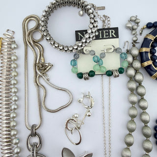 Reserved Grace assorted vintage-inspired costume jewelry collection featuring silver chains, beads, and navy bangles.