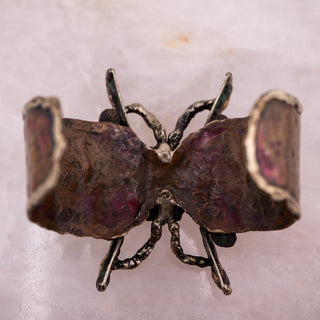 Reserved Grace handmade Brutalist cuff bracelet with textured metal butterfly wing design and orange glass cabochon.