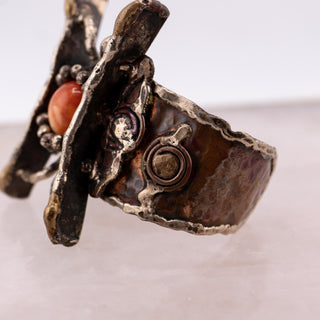 Reserved Grace handmade Brutalist cuff bracelet with textured metal frame and a central orange glass cabochon stone.