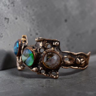 Reserved Grace brutalist cuff bracelet in silver-tone metal with three iridescent dichroic glass cabochons.