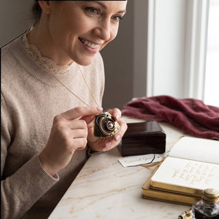 Reserved Grace brutalist mixed metal pendant with layered bronze and copper spiral details worn by a smiling woman.