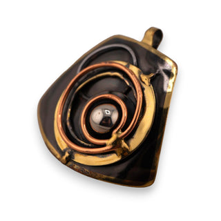 Reserved Grace brutalist pendant featuring layered bronze and copper spirals with a central silver-tone sphere.