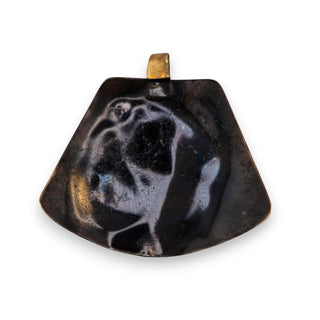 Reserved Grace brutalist mixed metal pendant featuring layered bronze and copper spiral details on a quartz surface.