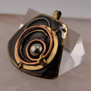 Reserved Grace brutalist pendant featuring layered bronze and copper spirals with a central silver-tone sphere.