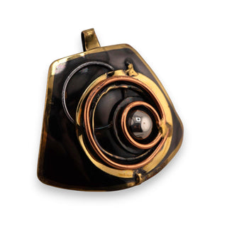 Reserved Grace brutalist pendant featuring layered bronze and copper spiral details on a dark mixed metal base.