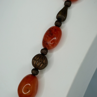 Reserved Grace vintage necklace with polished orange carnelian beads and textured metal spacer beads on a white surface.