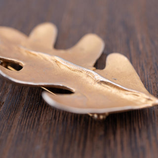 Reserved Grace vintage Carol Dauplaise gold-tone oak leaf brooch with textured brushed finish on a wooden surface