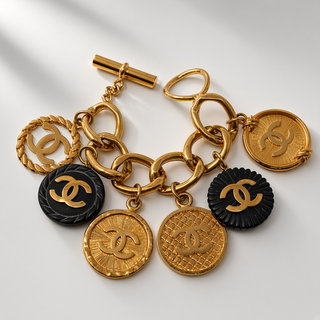 Reserved Grace vintage Chanel gold-plated charm bracelet featuring CC logo medallions and black resin accents