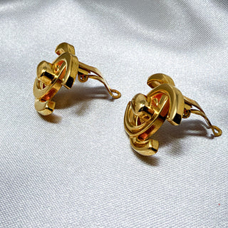 Reserved Grace vintage gold-plated Chanel CC turn lock clip-on earrings on a white fabric background