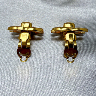 Reserved Grace vintage Chanel gold-plated CC turn lock clip-on earrings shown from the back on a grey satin background