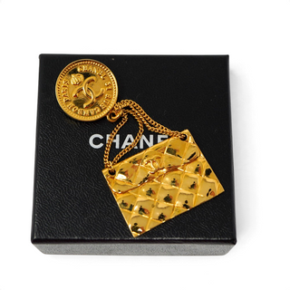 Reserved Grace vintage Chanel gold-tone brooch featuring a 31 Rue Cambon coin medallion and dangling quilted bag charm