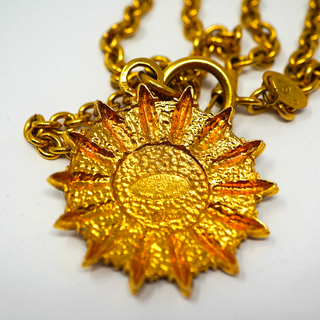 Reserved Grace vintage Chanel gold-plated sunburst medallion pendant necklace with textured detail on a long chain.