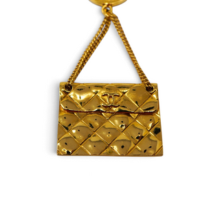 Reserved Grace vintage Chanel gold-plated brooch featuring a dangling miniature quilted handbag charm with CC logo