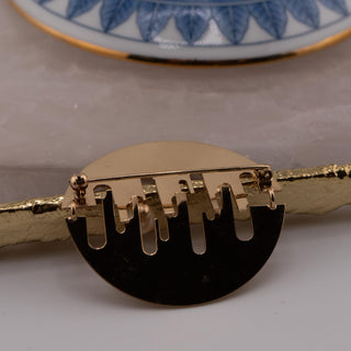 Reserved Grace gold tone abstract cut out brooch with mixed finish and pearl detail, back view showing pin mechanism.