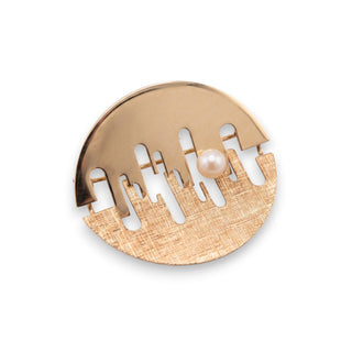Reserved Grace gold tone abstract circular brooch with mixed finish textures and a single white pearl accent.