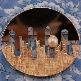 Reserved Grace gold tone abstract brooch featuring a mixed finish, cut-out design, and a single pearl accent.