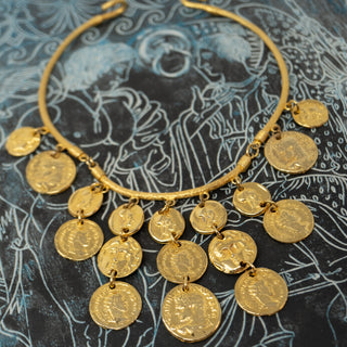 Reserved Grace gold-tone chunky coin choker bib necklace with intricate classical motifs on a dark patterned background