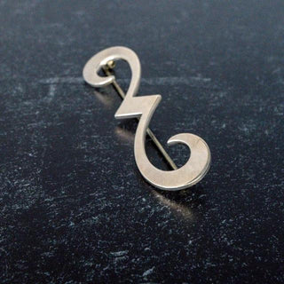 Reserved Grace James Avery retired sterling silver swirl brooch with a polished finish on a dark textured background