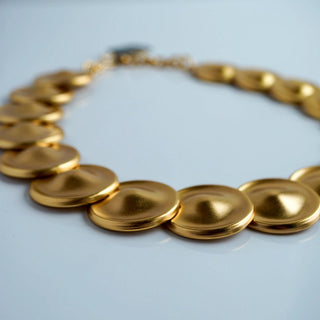 Reserved Grace vintage Monet gold-tone necklace featuring a sequence of linked matte disks with a warm metallic finish.