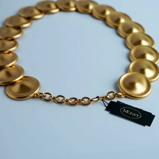 Reserved Grace vintage Monet gold-tone necklace featuring a sequence of matte circular disks on a linked chain.