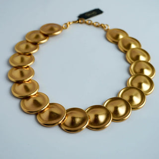 Reserved Grace vintage Monet gold-tone necklace featuring a sequence of matte circular disks in a linked design.