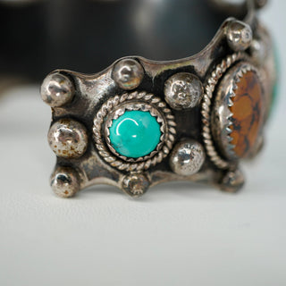 Reserved Grace vintage Navajo sterling silver cuff bracelet featuring a central ammonite fossil and turquoise stones.