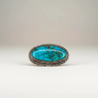 Reserved Grace vintage Navajo sterling silver pin featuring an oval turquoise cabochon with dark matrix patterns.