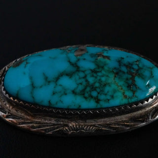 Reserved Grace vintage Navajo sterling silver pin featuring a large oval turquoise cabochon with dark matrix patterns.